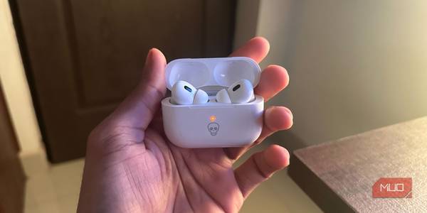 A guy holding AirPods Pro in charging case showing orange light