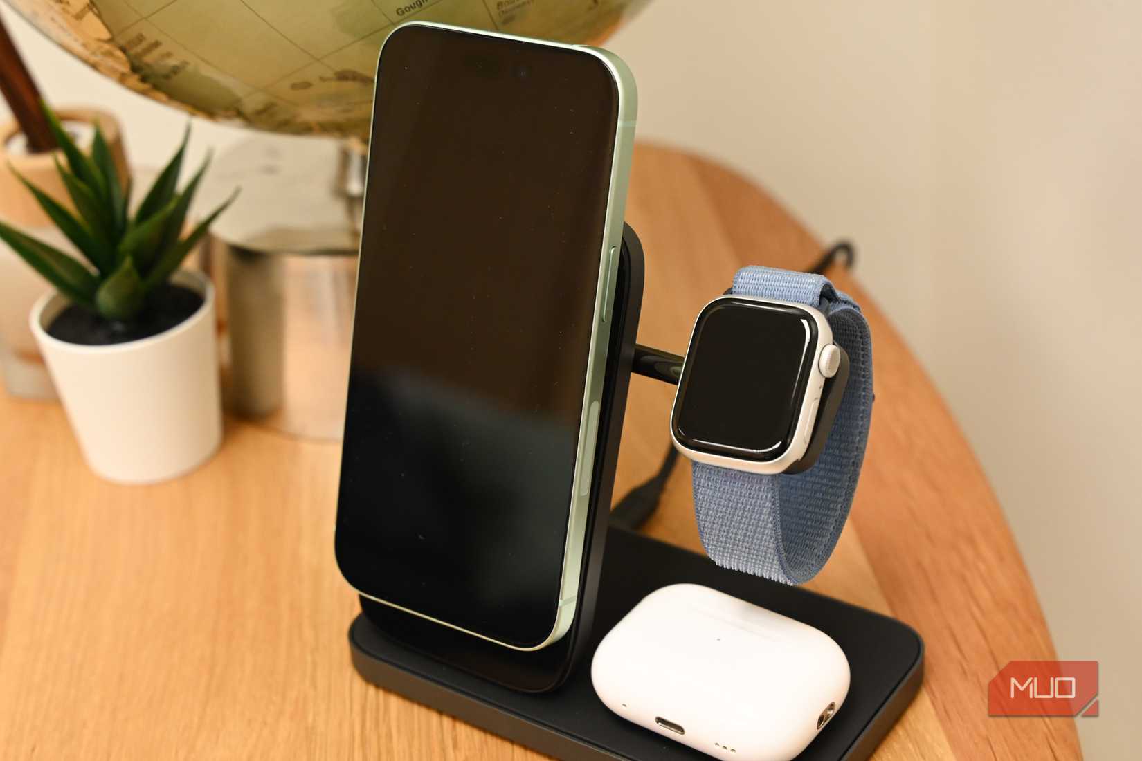 یک آیفون، اپل واچ و ایرپادها در حال شارژ بر روی استند Nomad Stand One Max