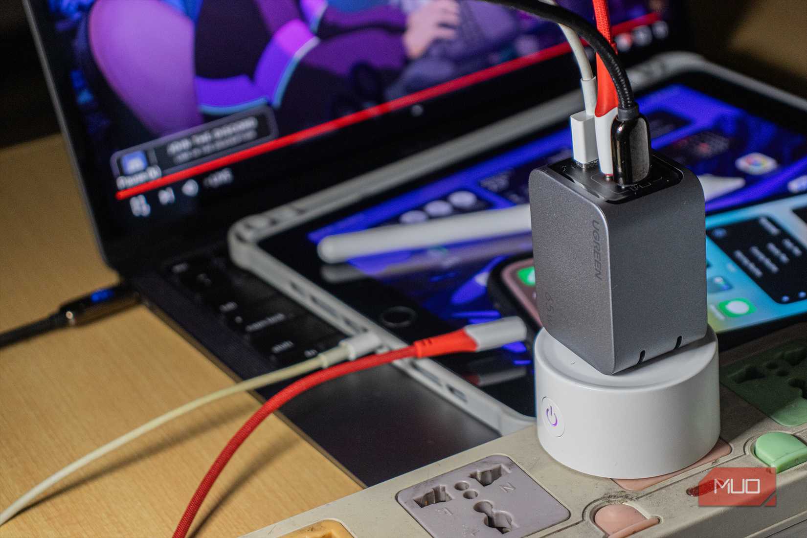 Ugreen Nexode Pro 65W Charger charging a laptop, tablet, and smartphone