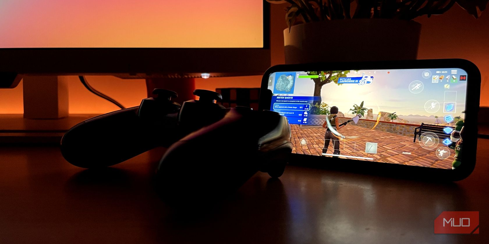 An iPhone running Fortnite with a PS4 controller connected to it.