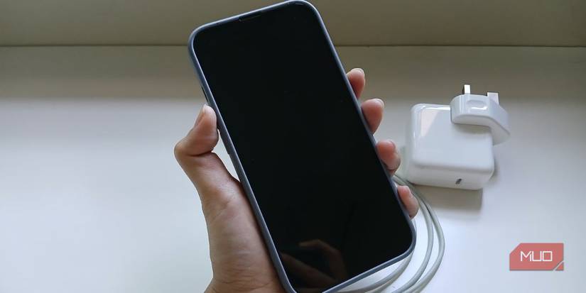 hand holding iPhone showing black screen