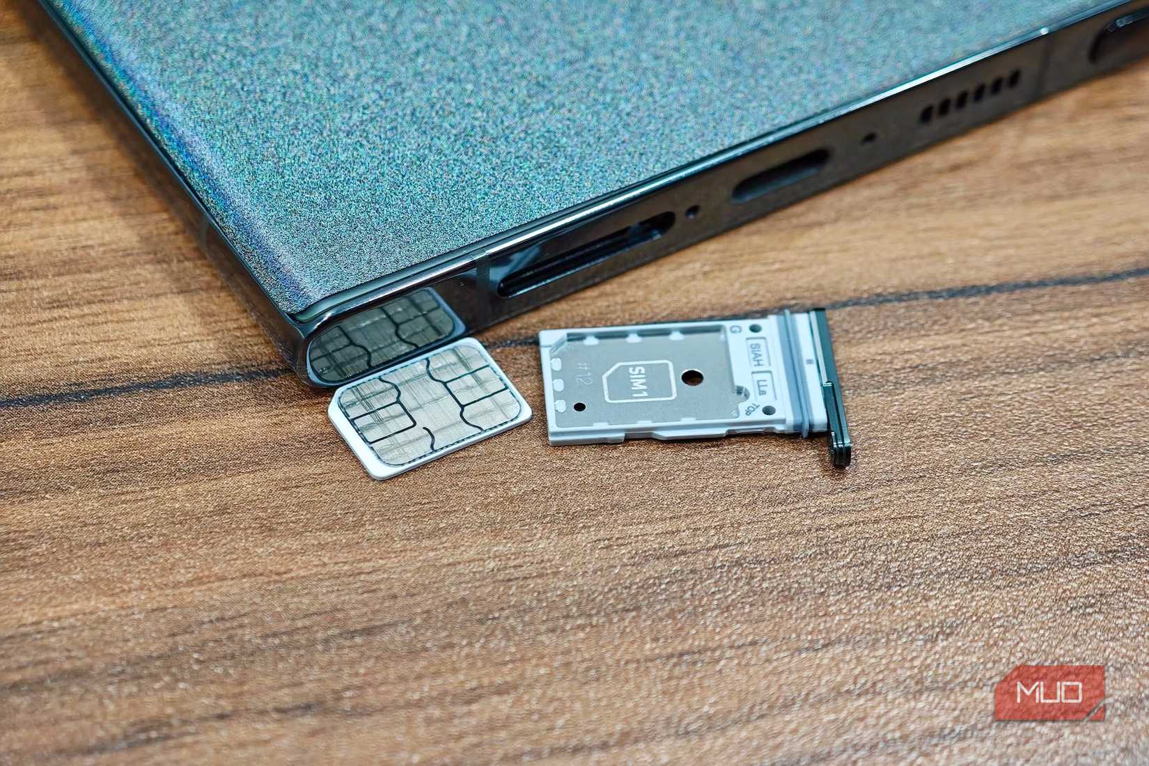 Samsung phone lying face down with a nano SIM and SIM card slot beside it