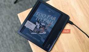 Charging the Kobo Libra Colour with the sleep screen on a book on desk