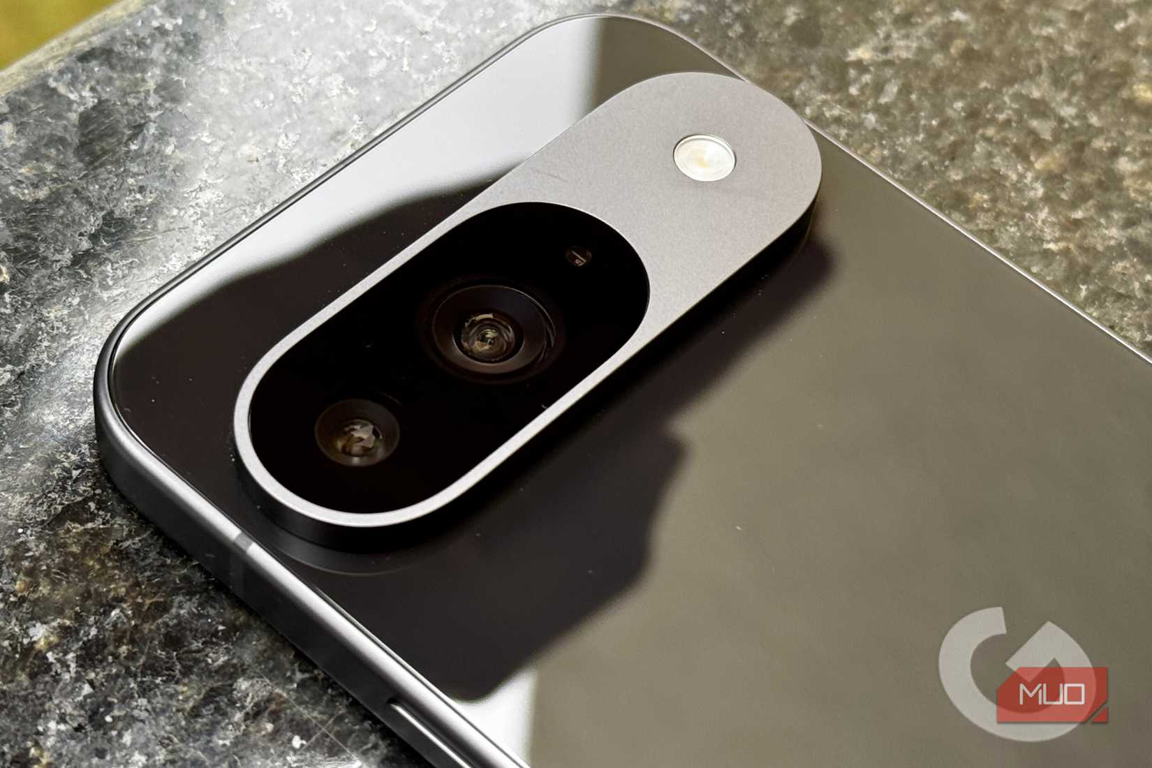 A close up shot of the Google Pixel 9's camera module on a black granite surface