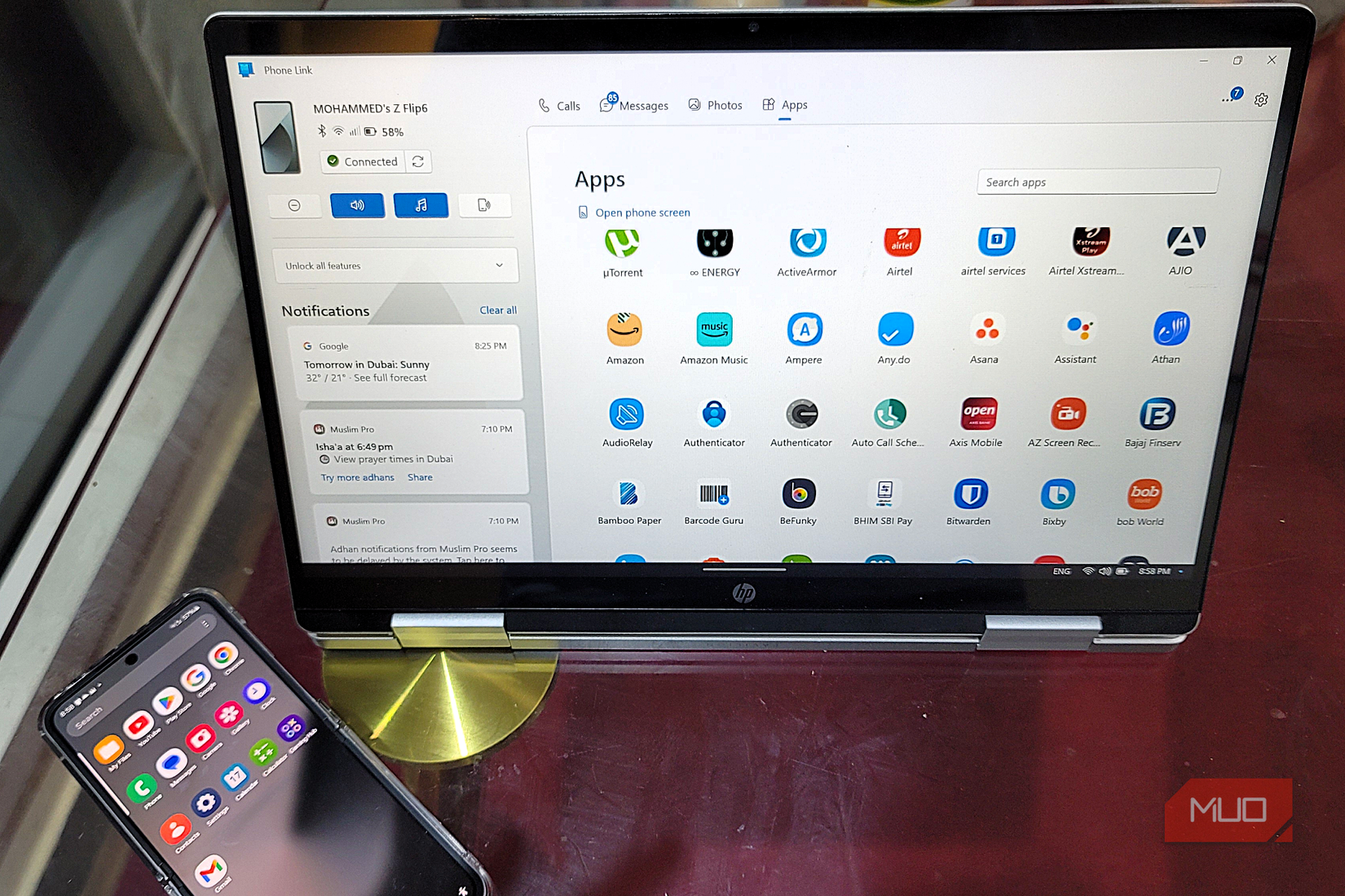 A Samsung Galaxy Flip 6 and a HP 2 in 1 Laptop on a glass top