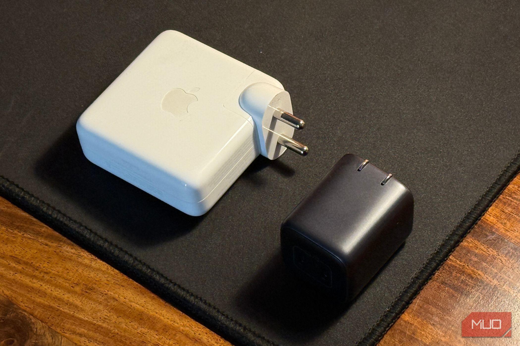 compact charger kept next to a larger macbook adapter