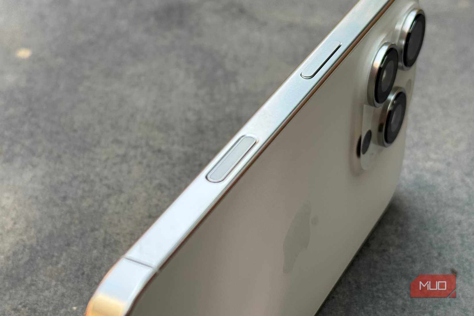 iPhone 16 Pro kept on a stone slab with focus on its right edge with the camera control button