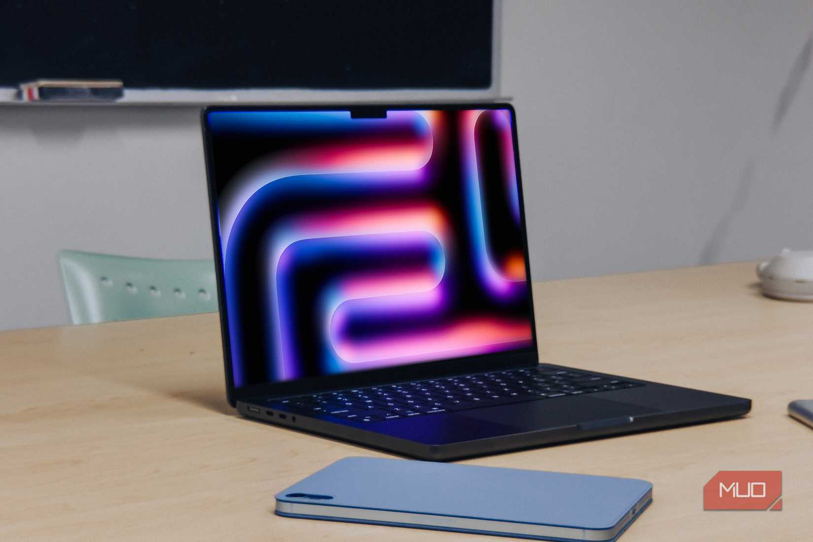 M4 MacBook Pro کنار iPad روی میز چوبی