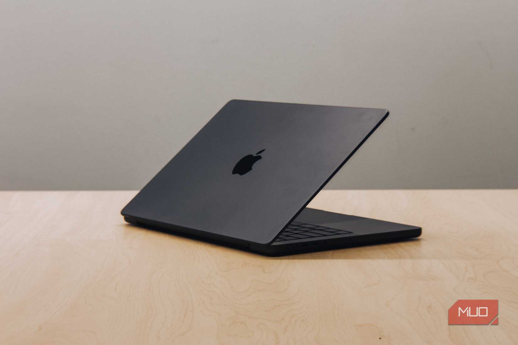 M4 MacBook Pro with screen tilted down on wooden table