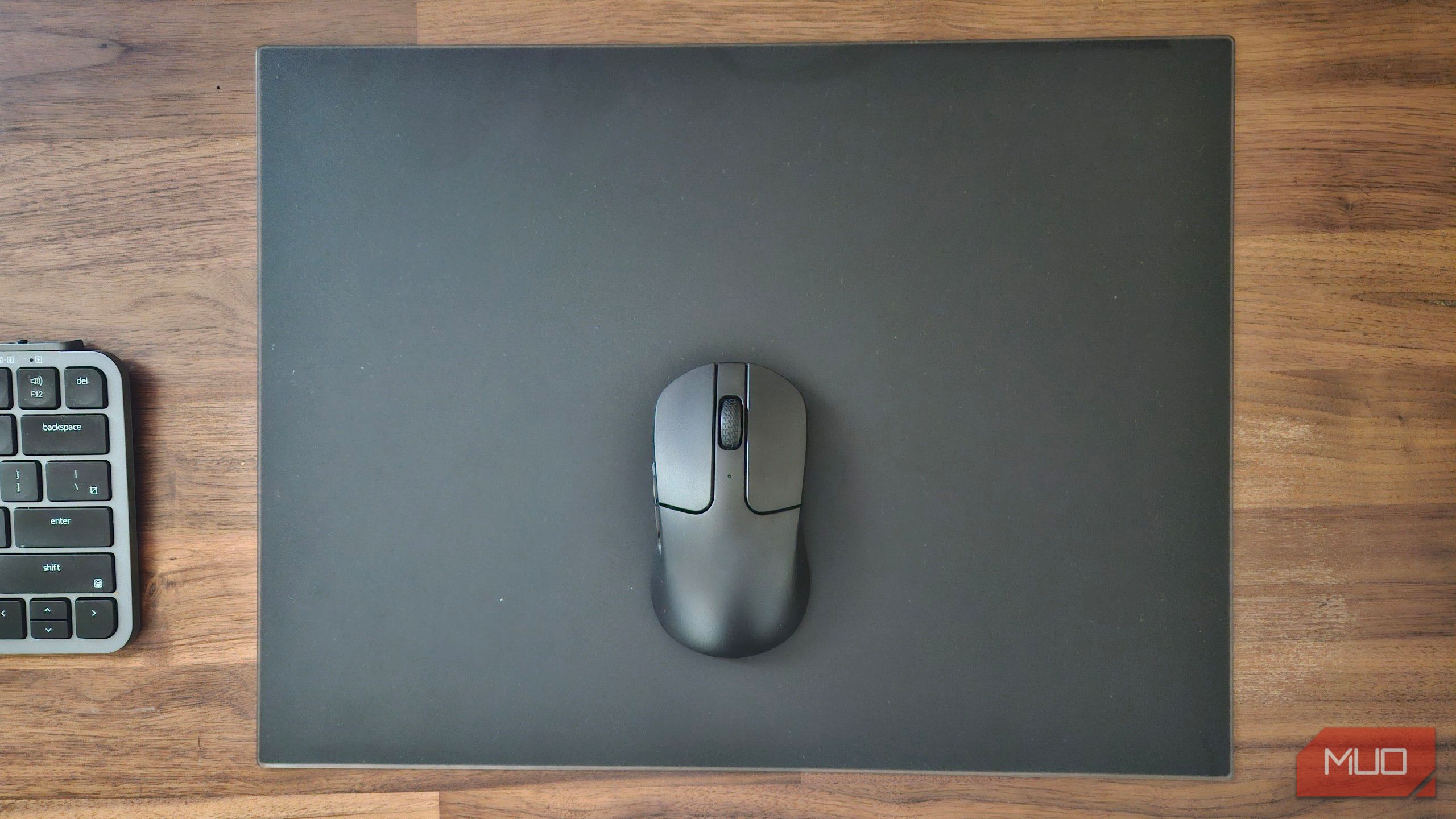A tempered glass mousepad with Bluetooth mouse next to a Bluetooth keyboard.
