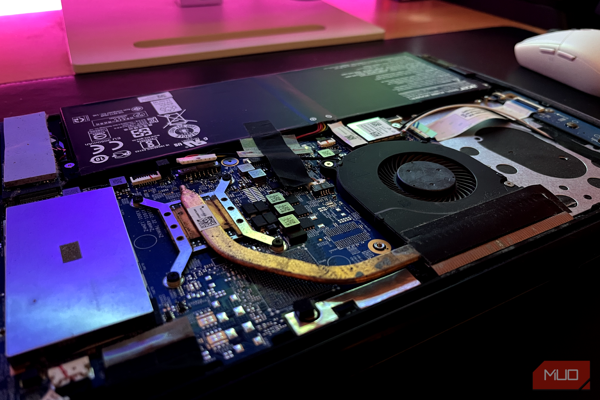 A laptop with its internal components exposed, showing dirt and debris around the heatsink.