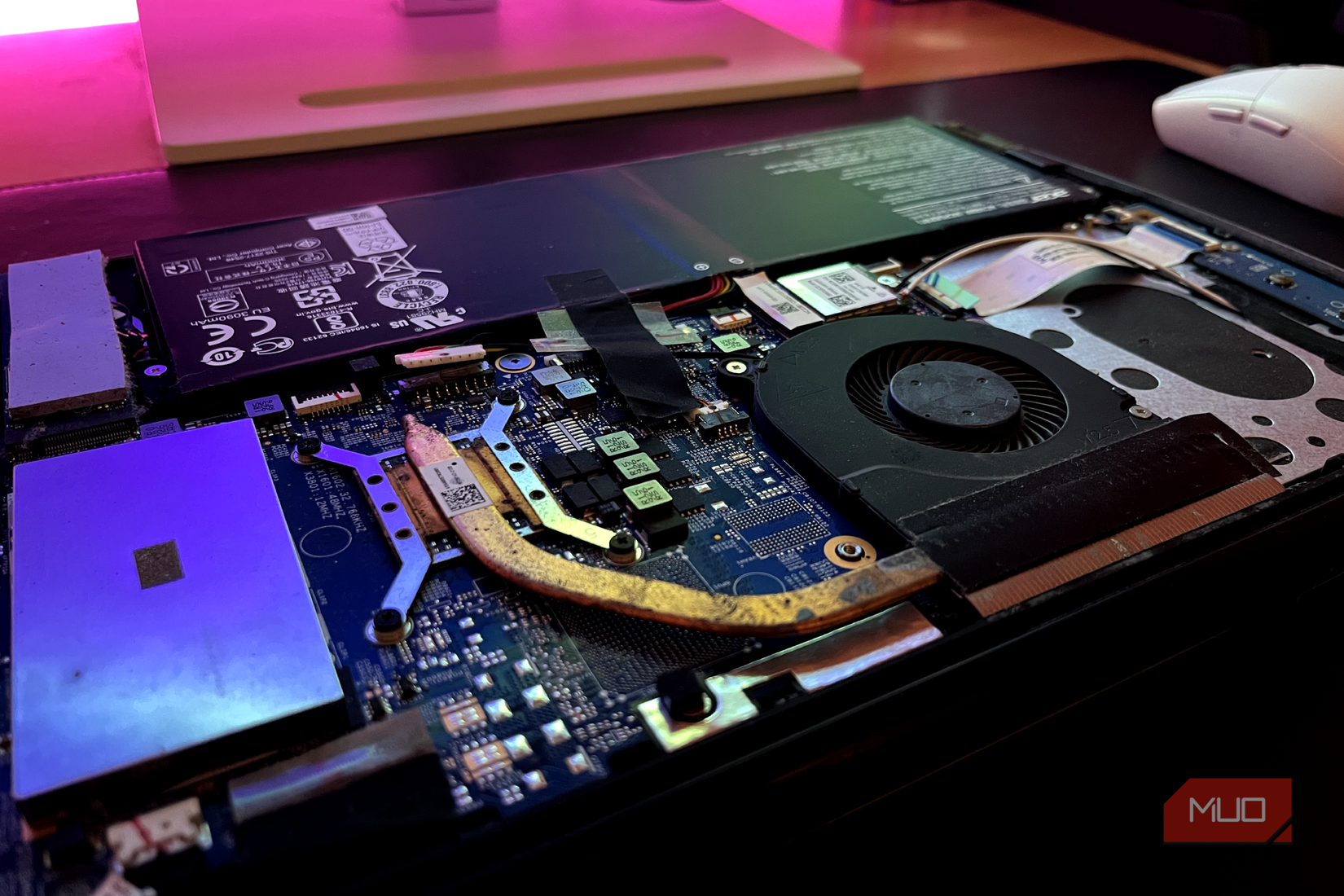 A laptop with its internal components exposed, showing dirt and debris around the heatsink.