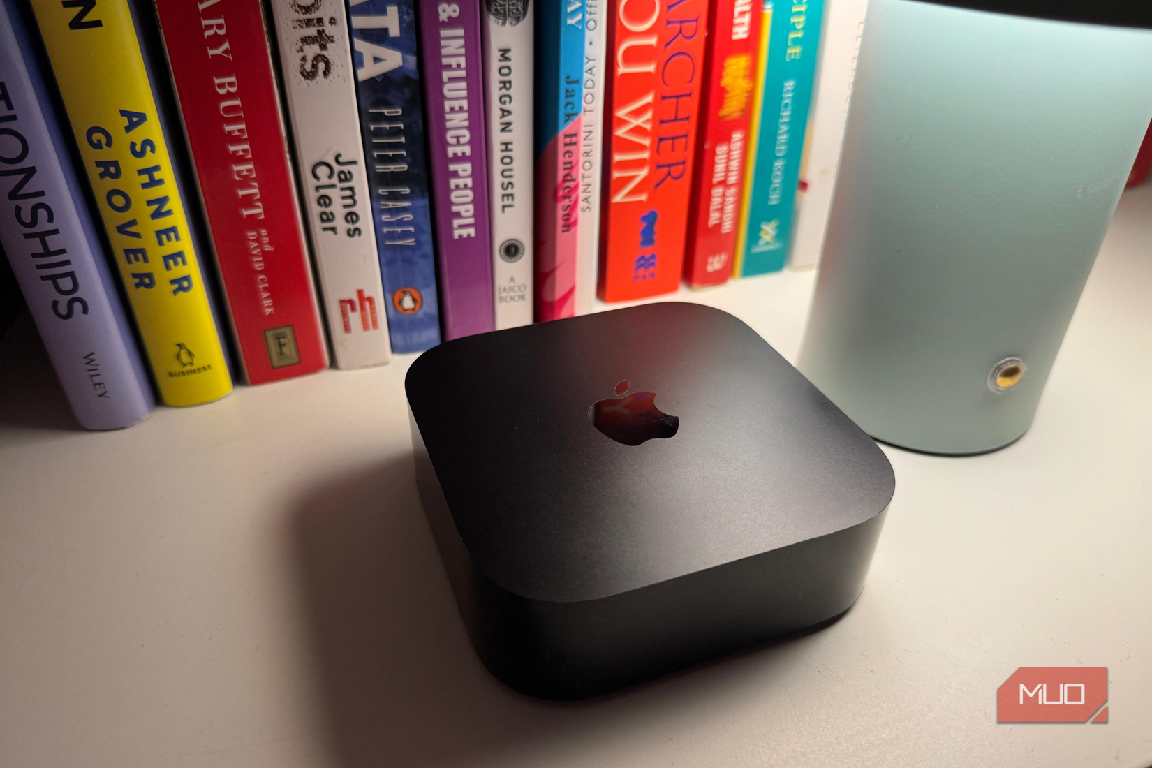 বাতির পাশে অ্যাপল টিভি আর ব্যাকগ্রাউন্ডে কিছু বই