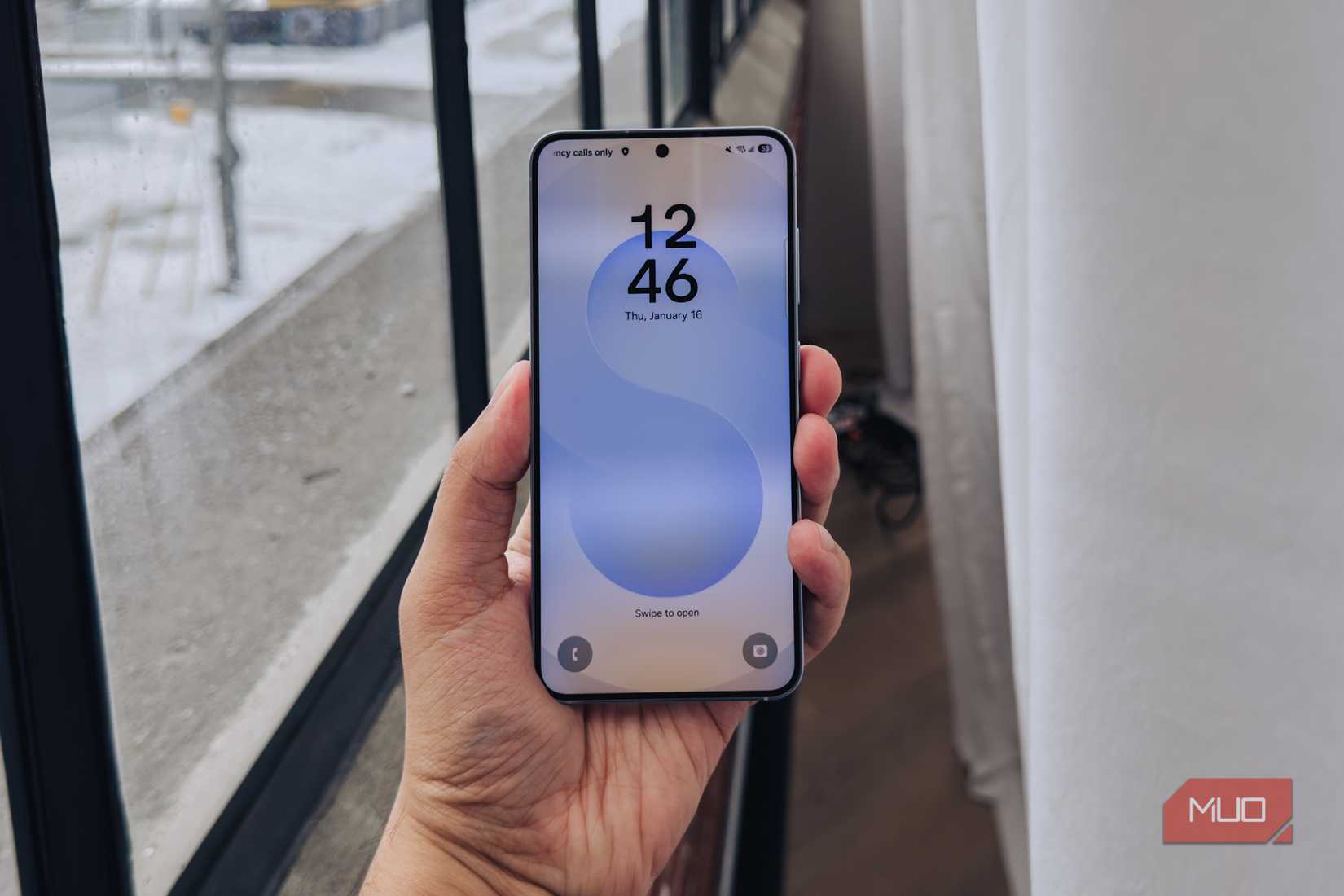 Samsung Galaxy S25 lockscreen against a window.