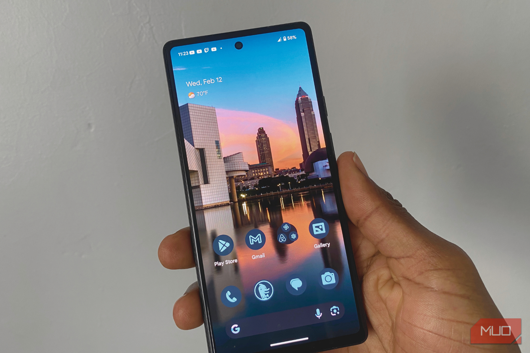 A hand holding a Google Pixel 6a smartphone that is powered on