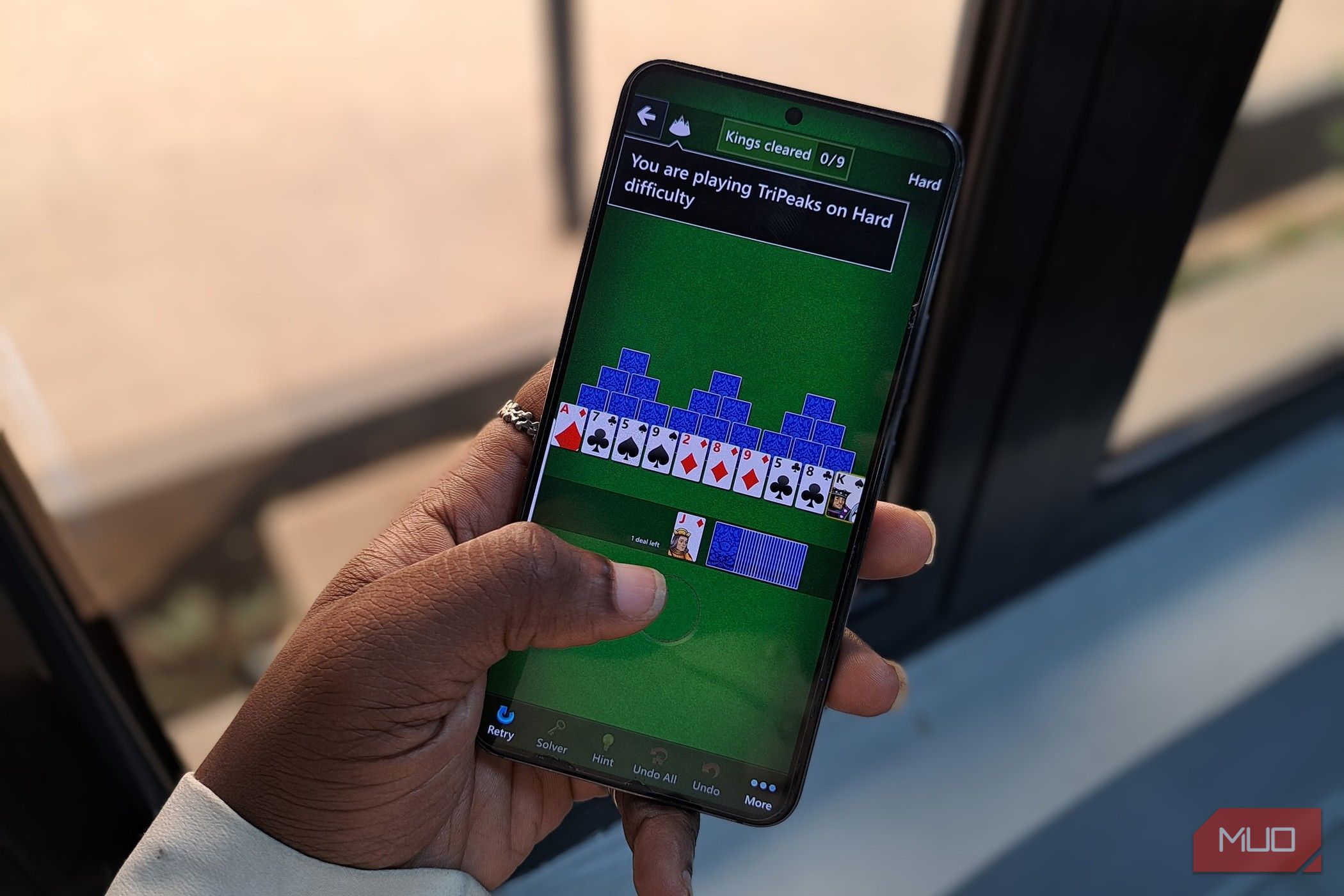 Someone playing Microsoft Solitaire on a mobile phone