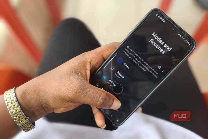 Hand holding a Samsung phone showing Mode and Routines