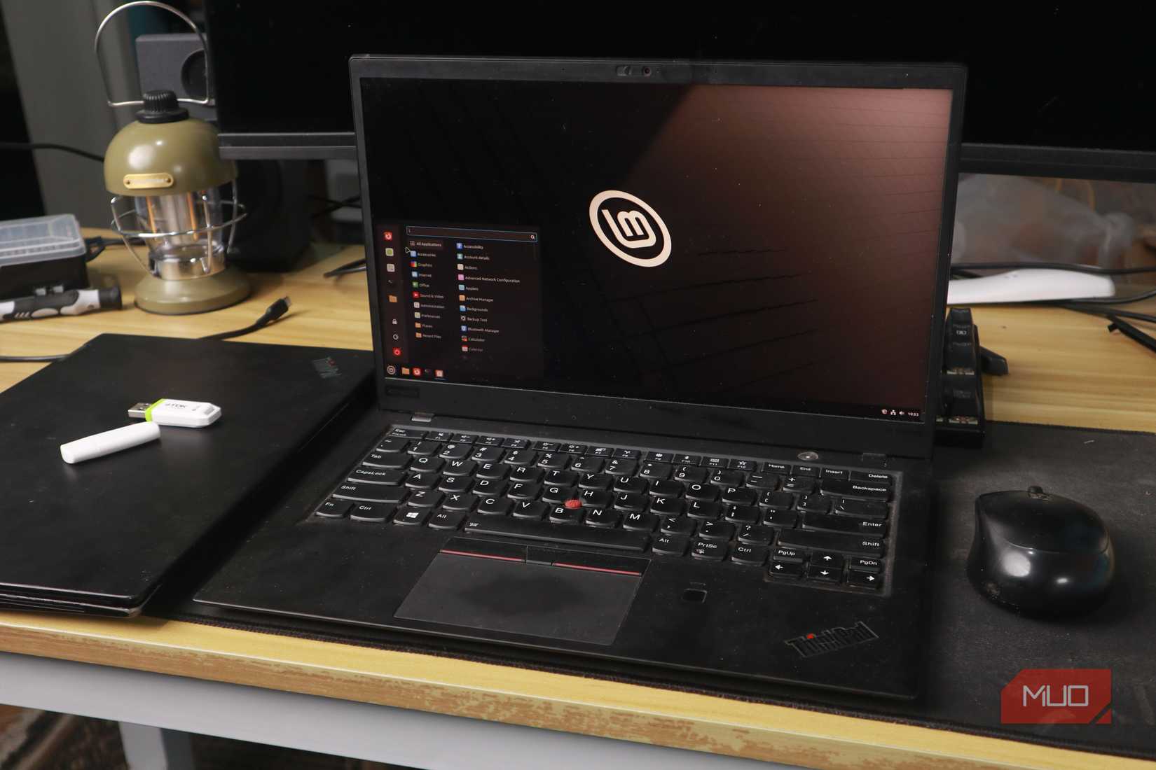Linux Mint desktop on a ThinkPad laptop, with a mouse and USB stick nearby