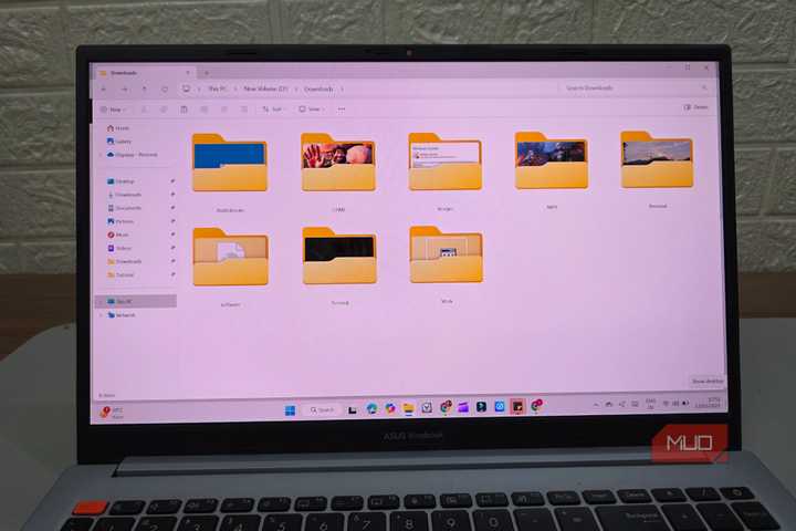 A laptop sitting on a desk displays an open file explorer window