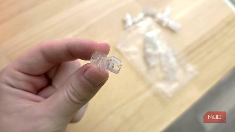 A hand holding an LED strip to wire connector