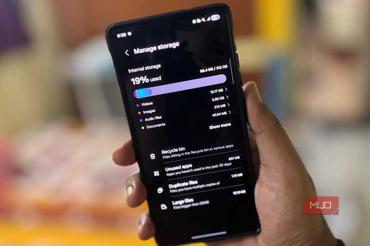 A man holds a Samsung phone and opens it to view the free and used storage space