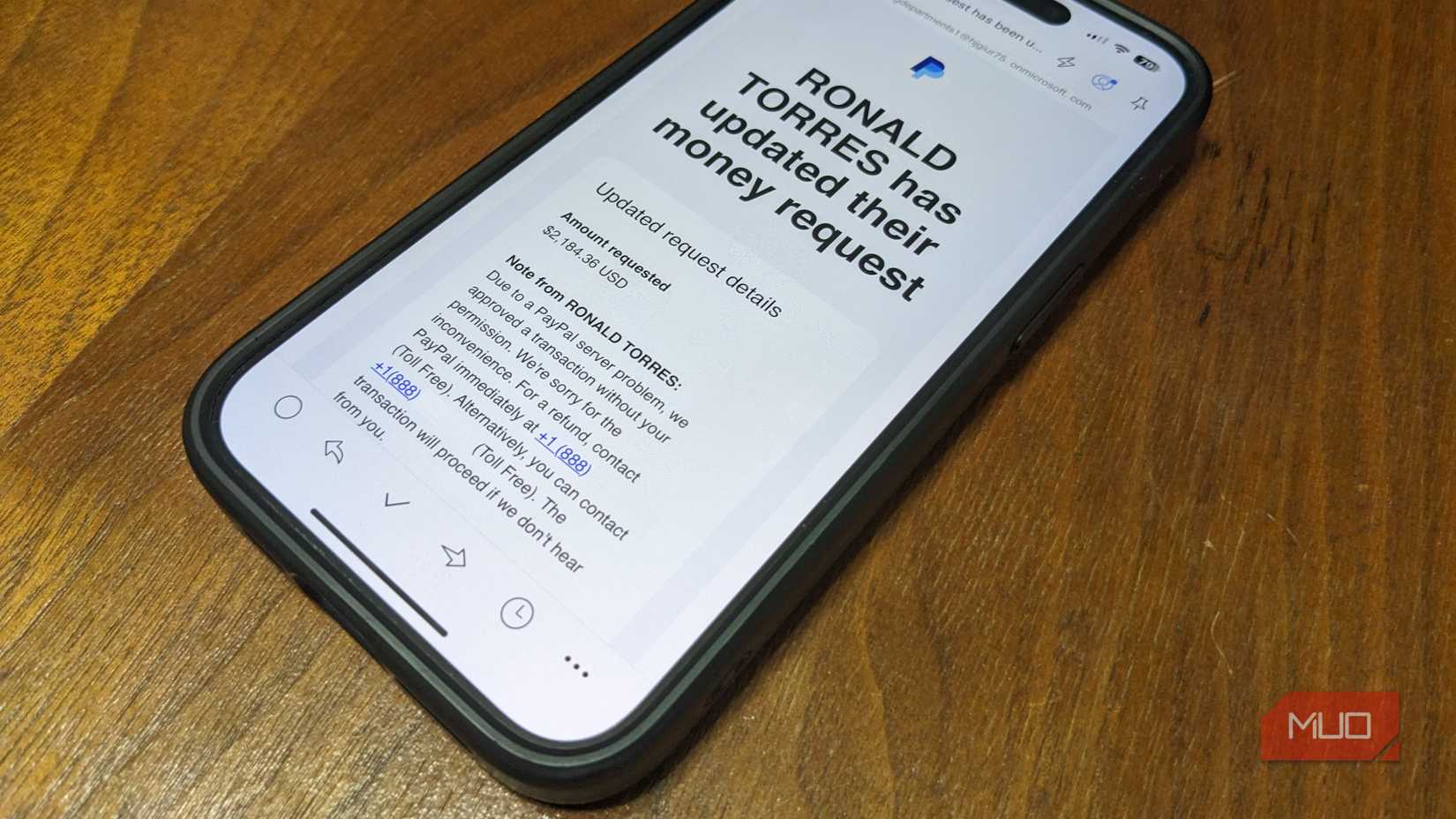 Fake PayPal Invoice Scam Email on a wooden surface