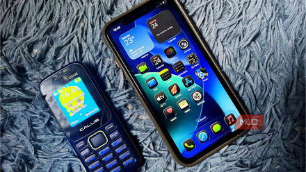 iPhone 11 and a feature phone placed on a blue background