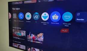 TCL Google TV on wall showing apps on home screen