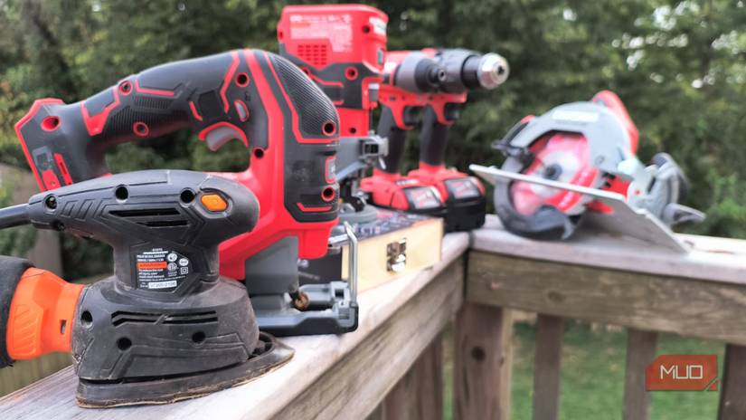 An array of power tools atop a wooden rail
