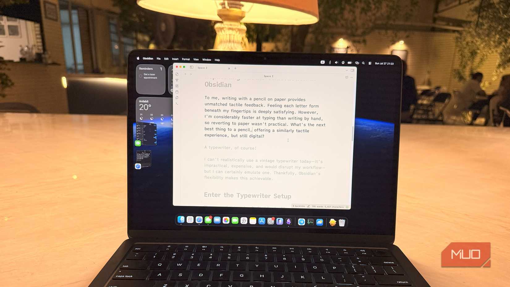 A laptop on a table with Obsidian note-taking app on the screen