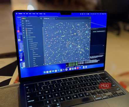 A MacBook on a sofa showing an open view of Obsidian's graph view alongside a local LLM