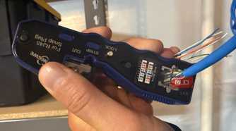 Crimping ethernet cable with crimp tool in hand