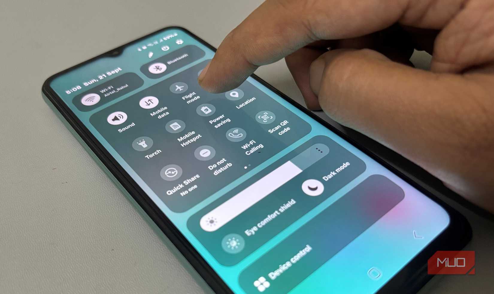 Finger tapping Quick Settings panel on Samsung phone screen