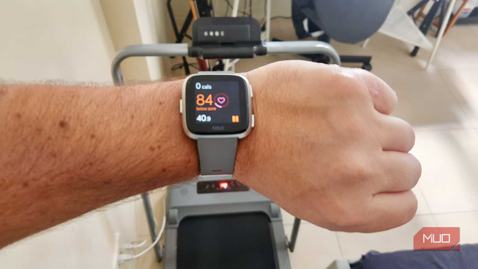 A FitBit fitness watch above a treadmill.