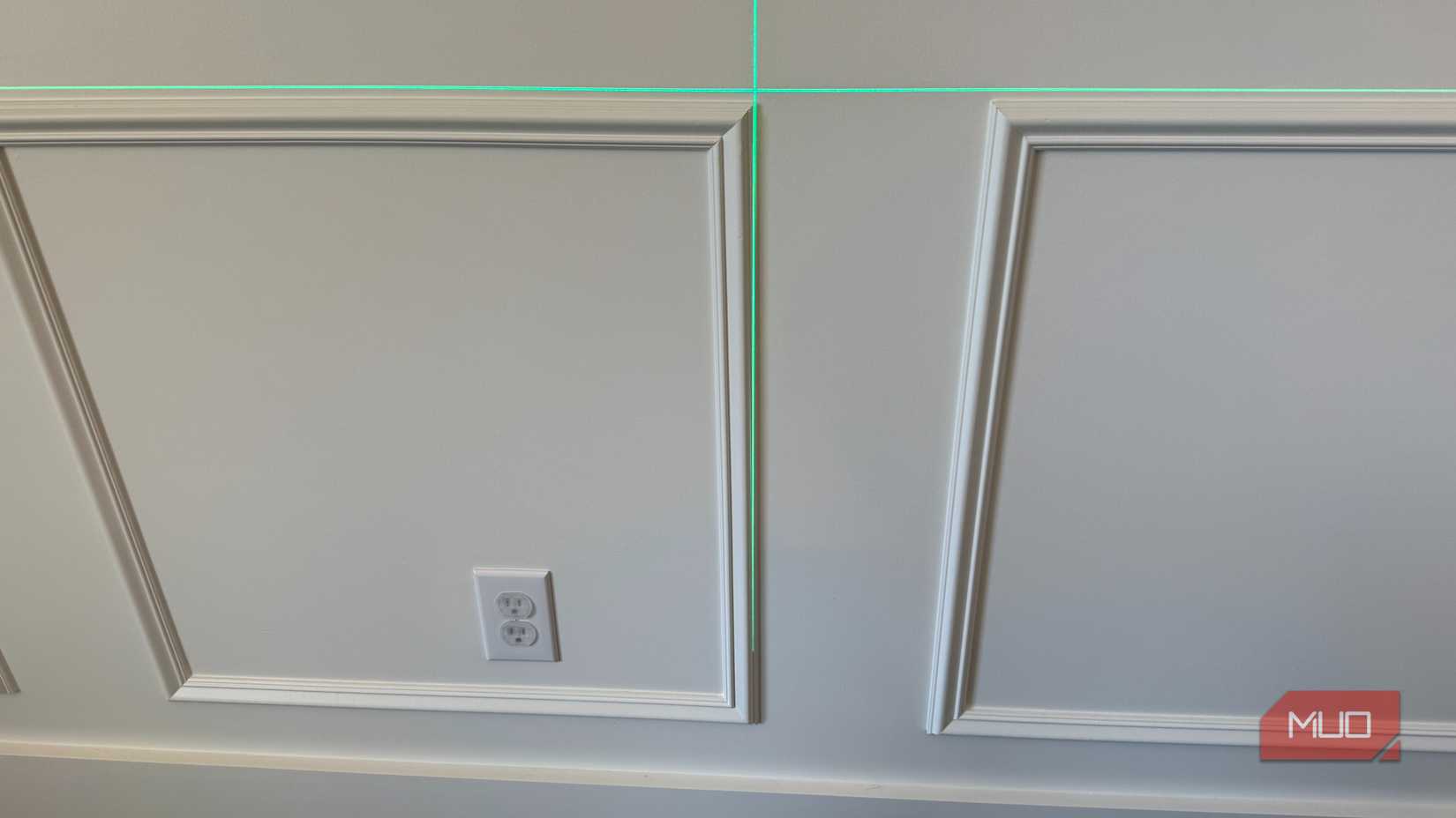 green laser level pointed at wainscoting