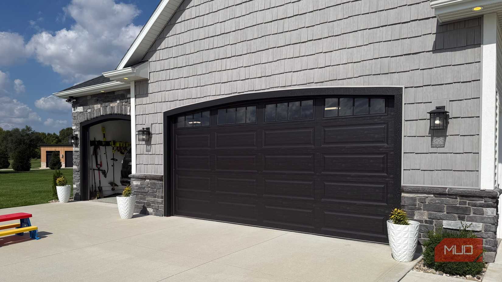 grey house with 2 garage doors with one opened