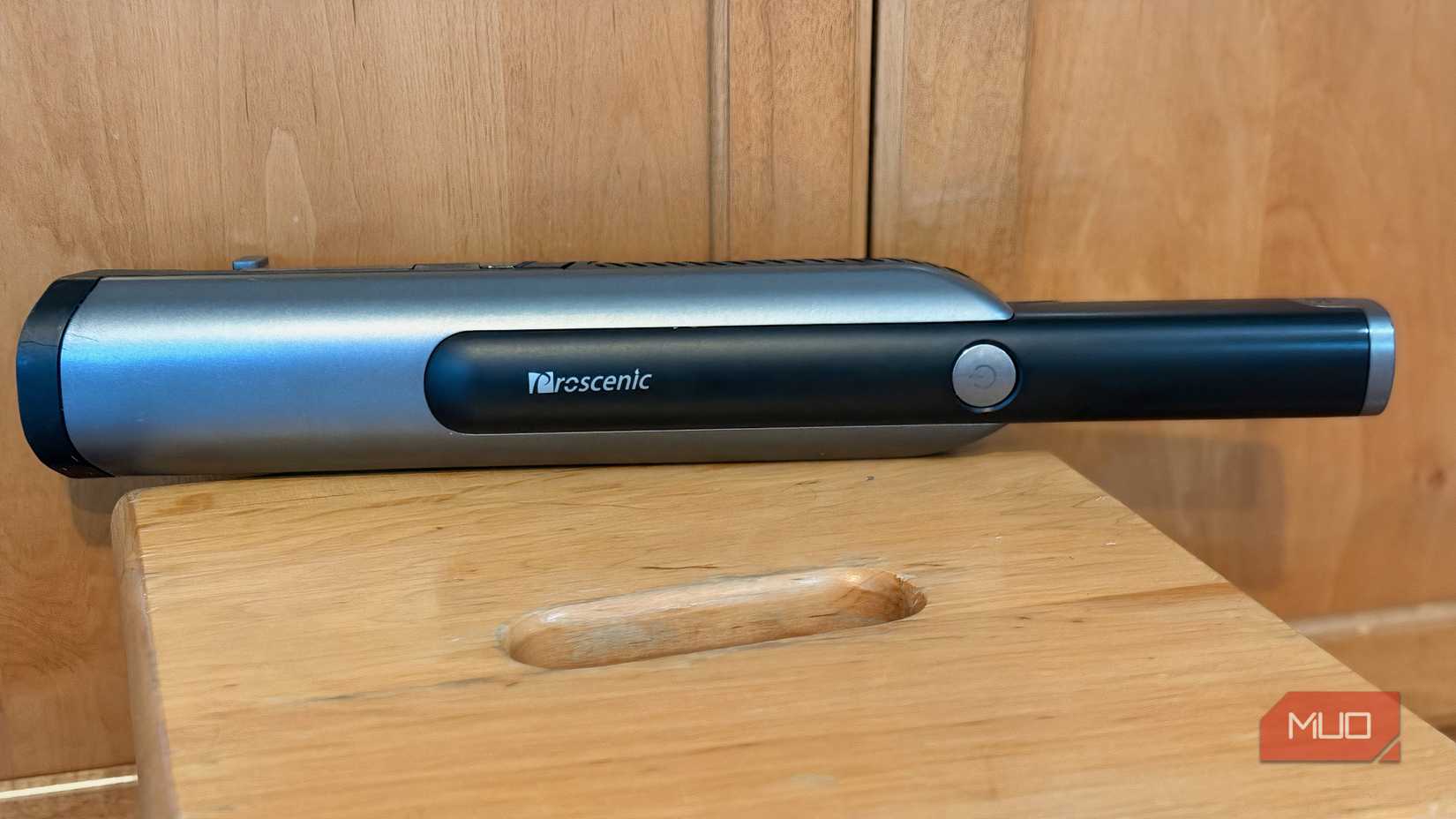 A black hand-held vaccum sitting on a surface.