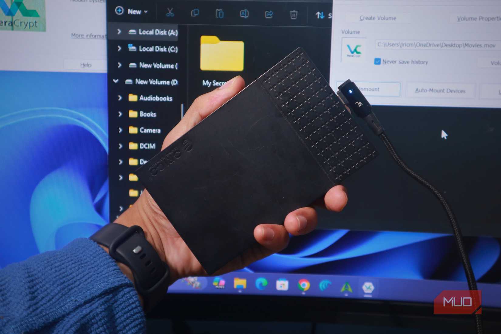 Holding up a plugged external hard drive.