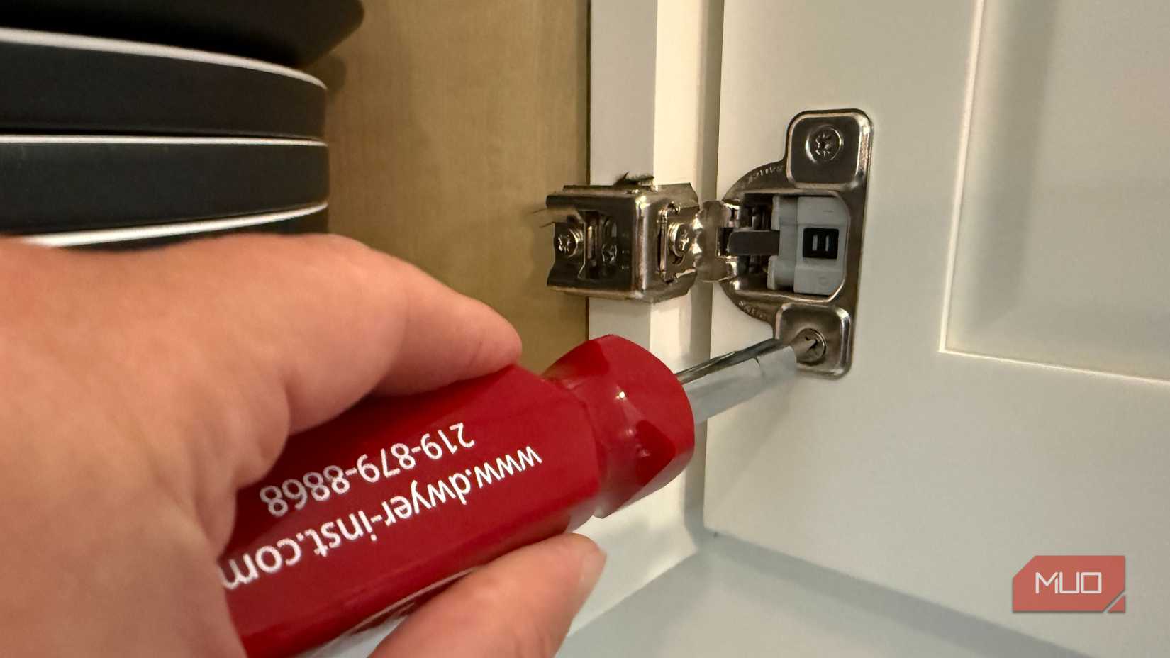 adjusting kitchen cabinet hinge with screwdriver