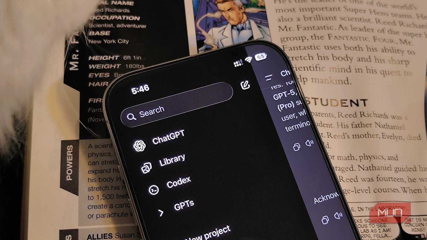 An iPhone with the ChatGPT app open on a book