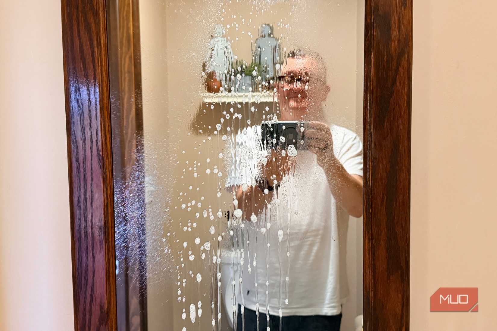 A person cleaning a mirror.
