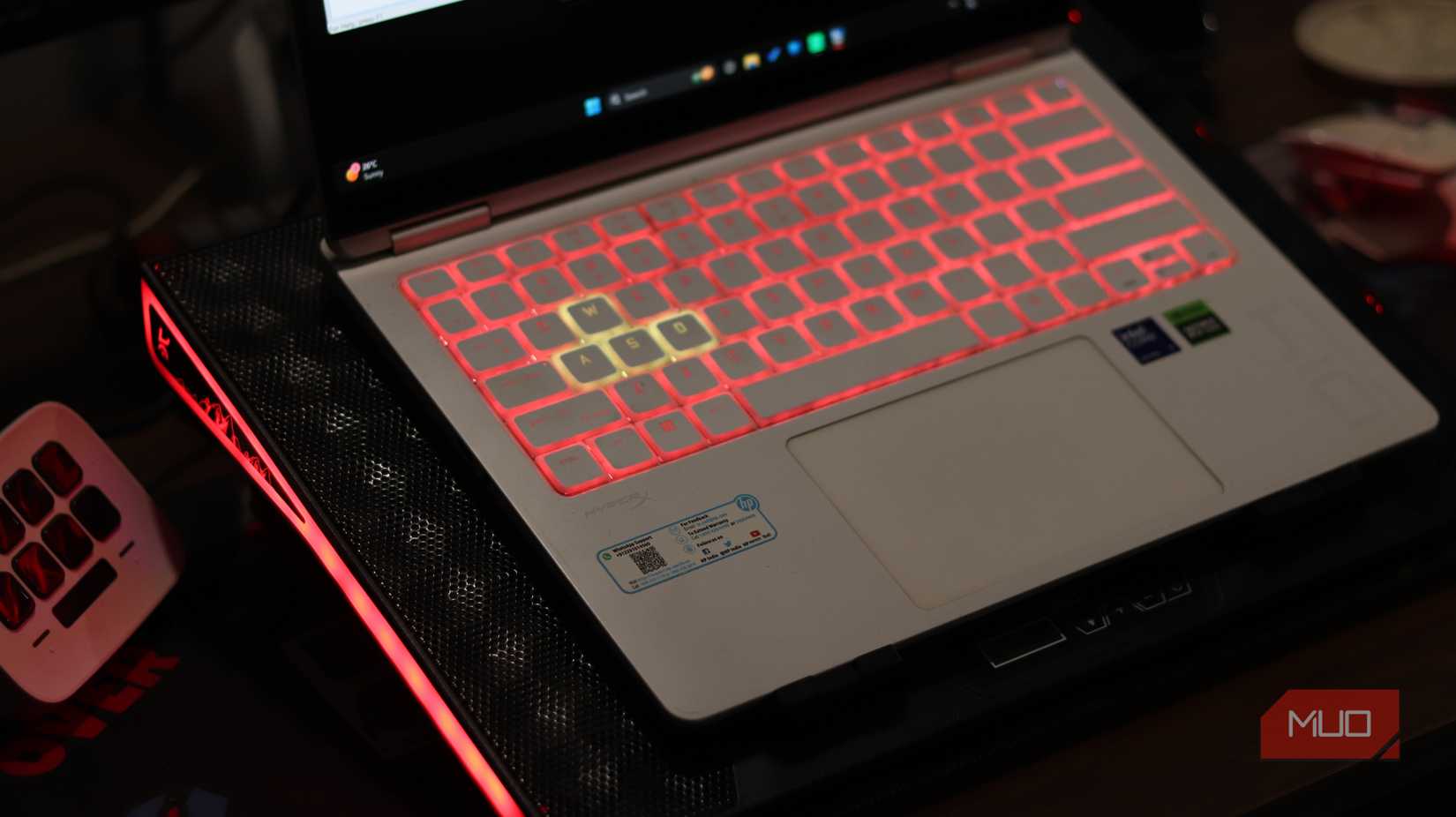 HP Omen gaming laptop on a cooling pad with red backlight.