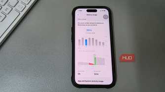 iPhone showing Battery Usage screen placed on a desk beside a keyboard.