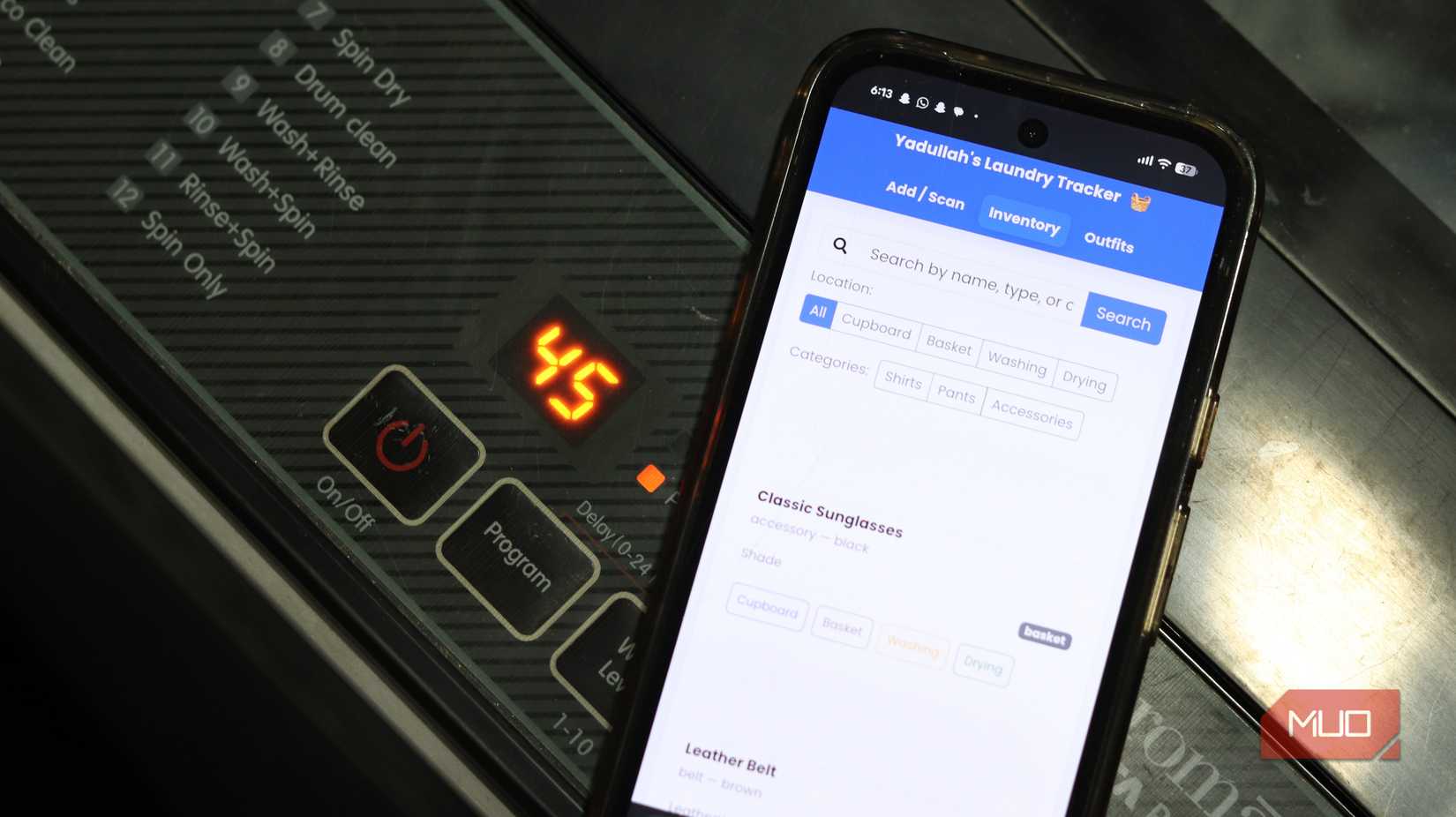 Laundry tracking app running on phone near a washing machine.