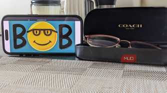 Microsoft Bob Logo on Phone Next to Glasses Case