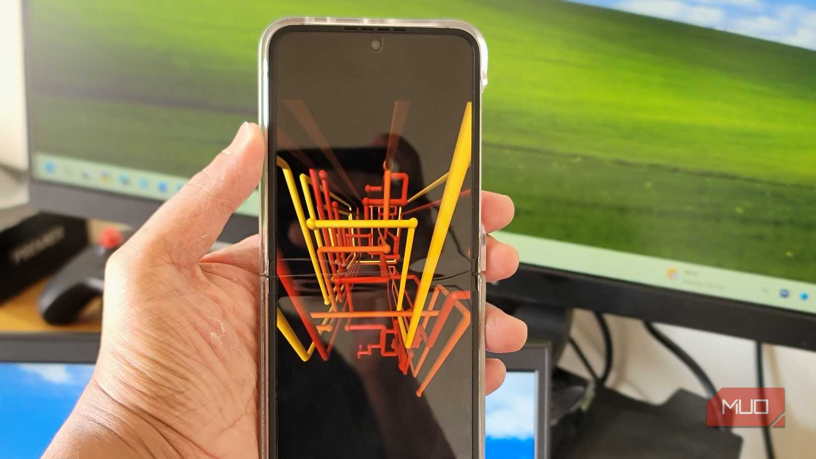 Person holding a Z Flip 6 with the classic XP 3D wipe screen saver active