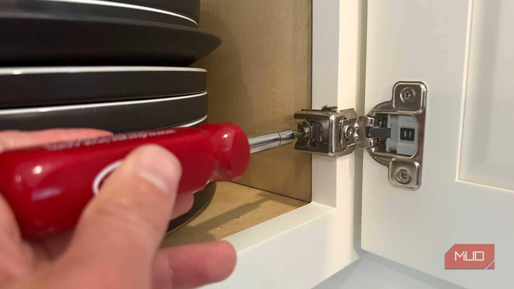 removing cabinet hinge with screwdriver