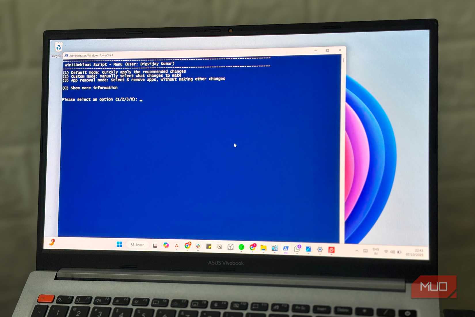 Running Windows debloat script in PowerShell on a laptop screen.