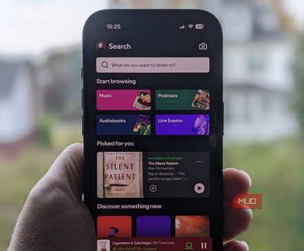 صفحهٔ اصلی اسپاتیفای بر روی آیفون در مقابل یک پنجره