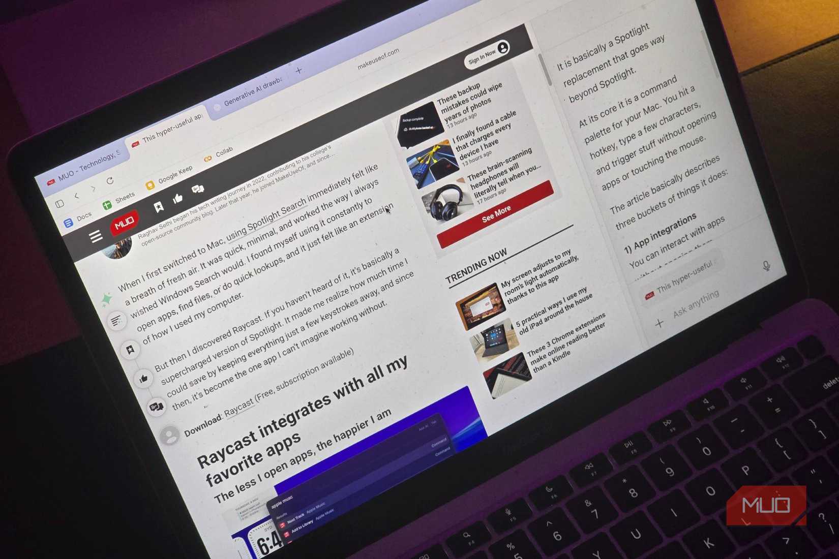 A MacBook with a MakeUseOf article open in ChatGPT Atlas